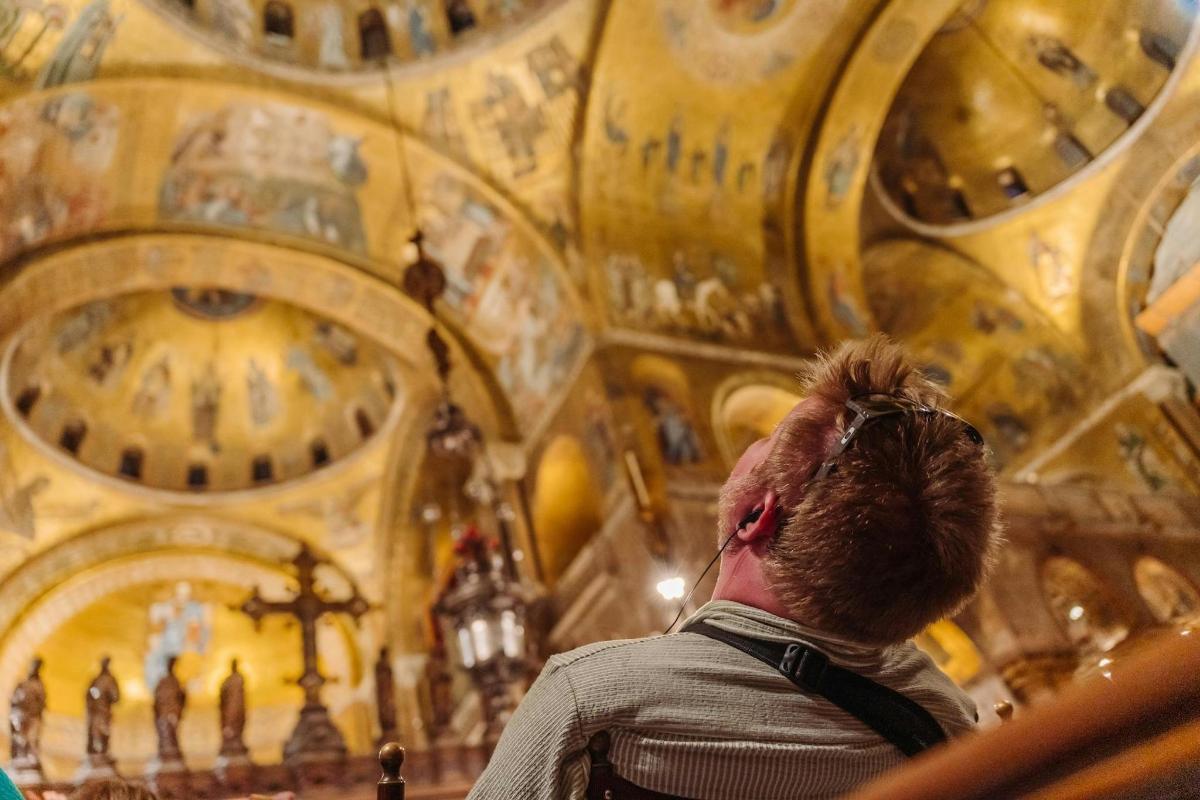 ein Mann, der zu einer Kirche mit einer Decke aufblickt