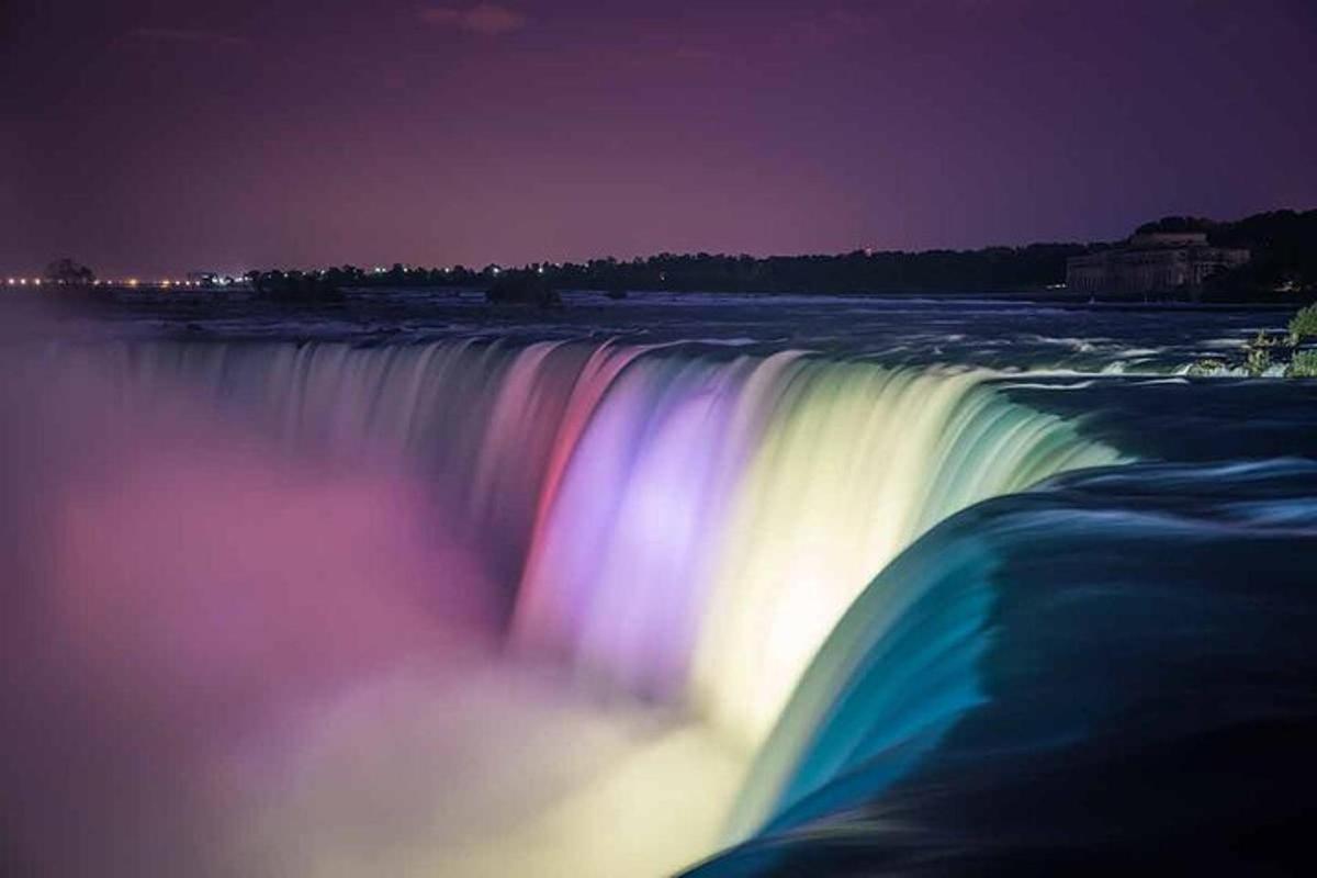 a large waterfall at night with a rainbow