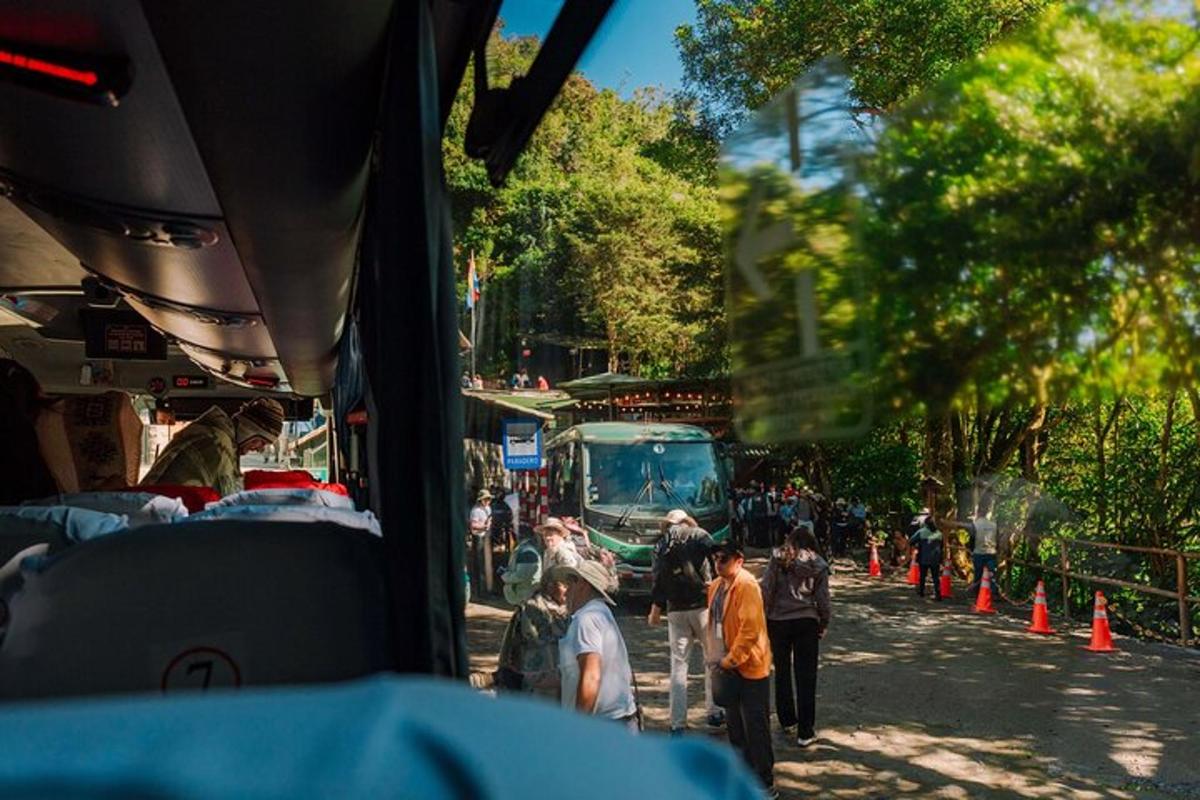 un grup de persones dempeus en un carrer amb un autobús