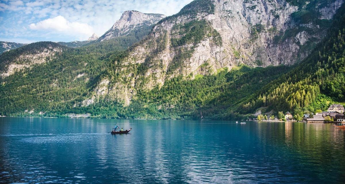 en båt på en innsjø foran fjellene