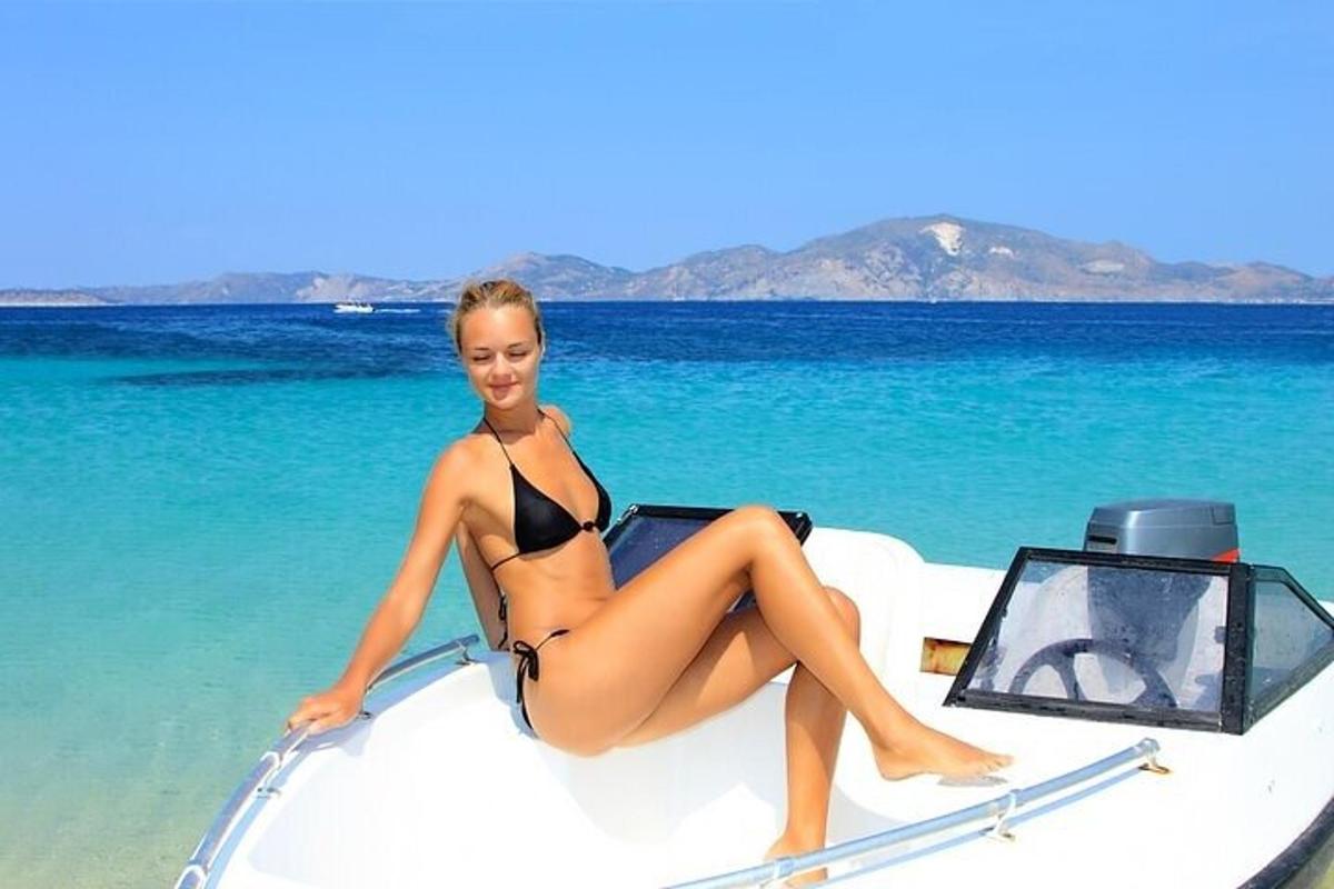 eine Frau im Bikini sitzt auf dem Bug eines Bootes