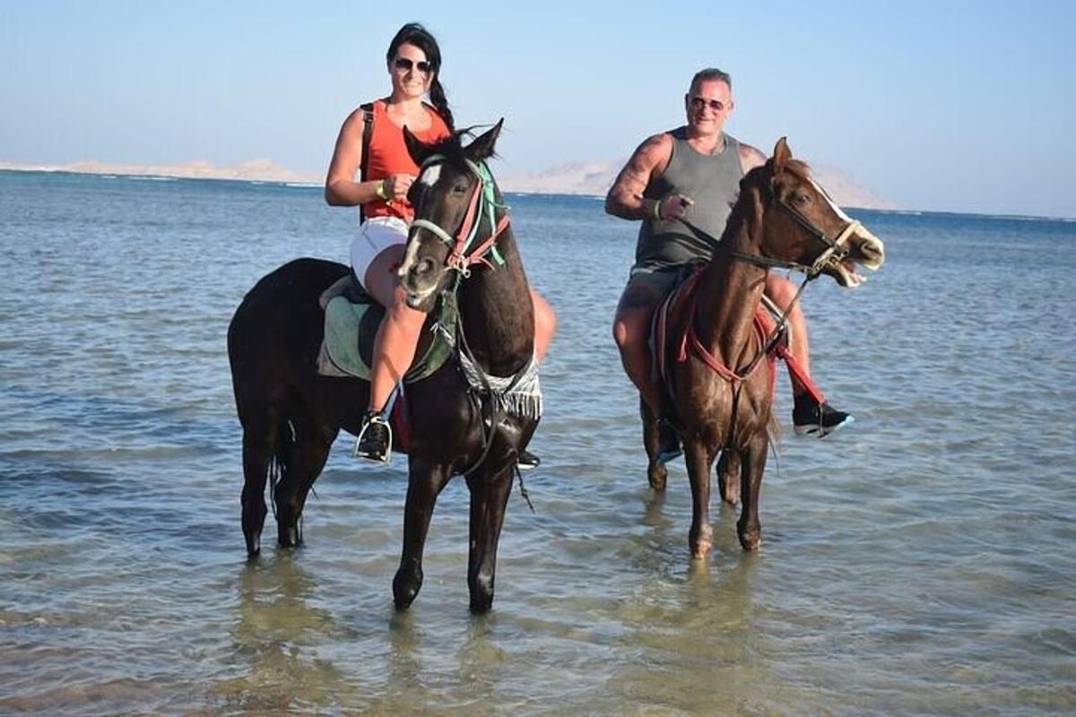 un uomo e una donna a cavallo nell'acqua