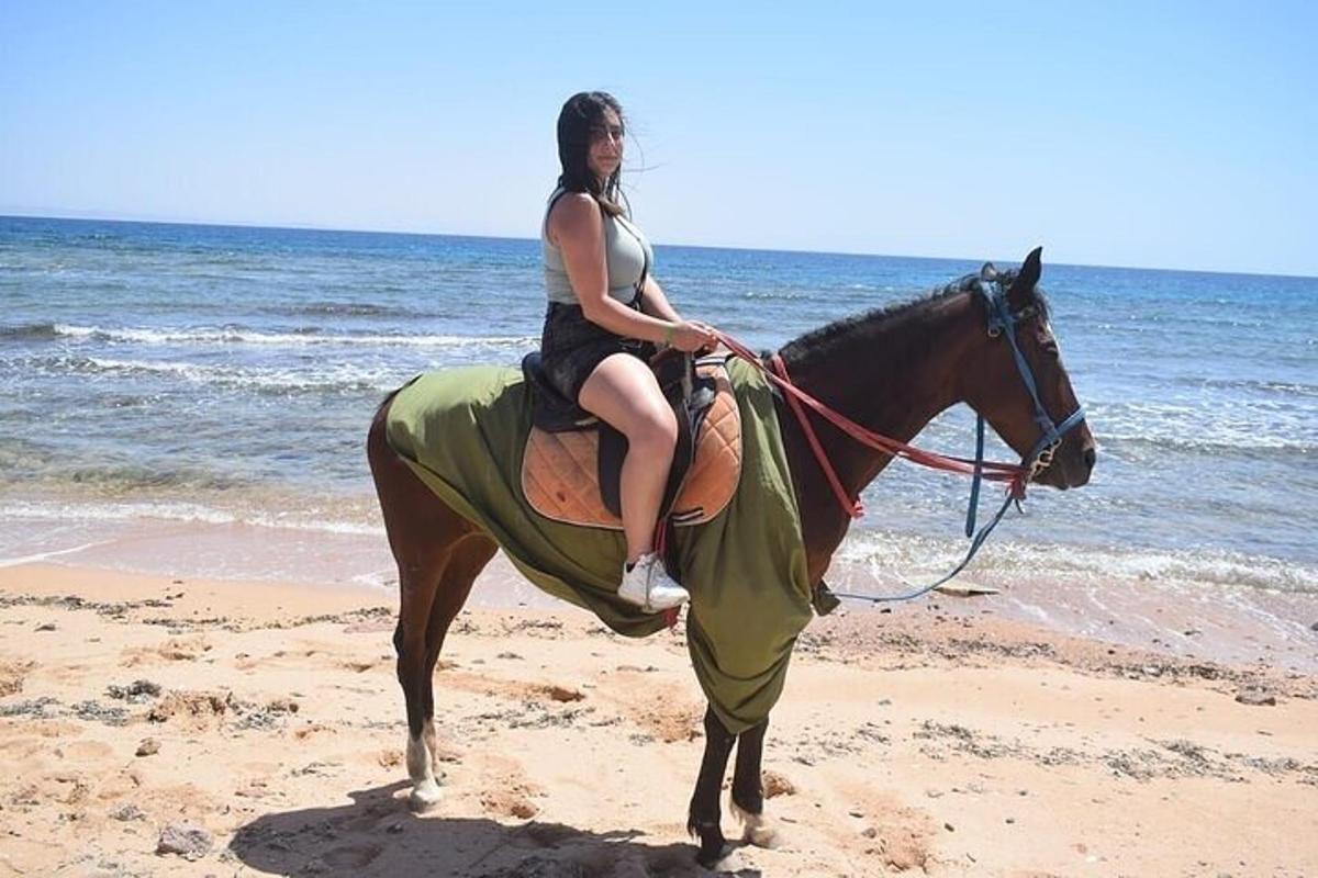 una donna a cavallo sulla spiaggia