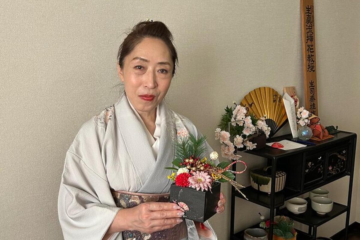 a woman in a kimono holding a box of flowers