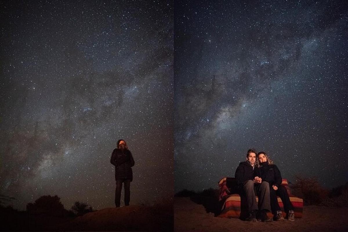 two people sitting on a bed looking at the universe