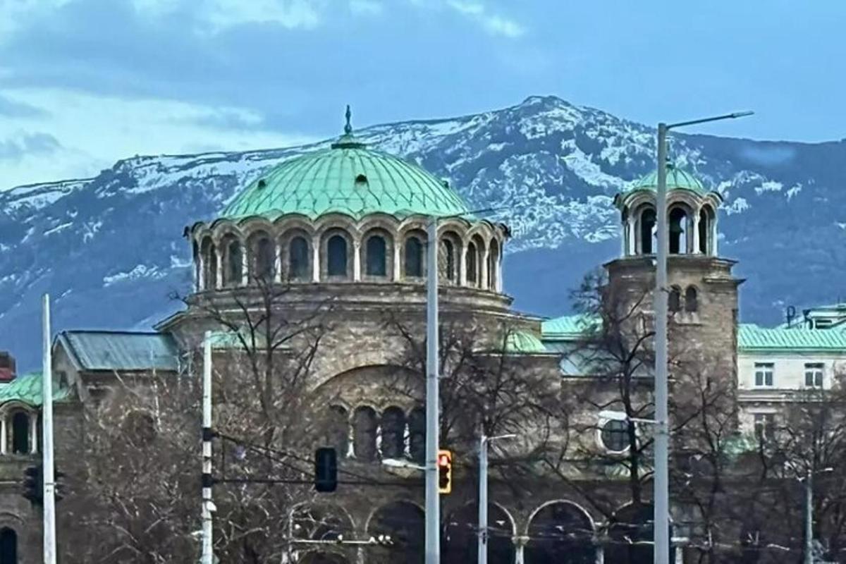 一座绿色屋顶的建筑，背景是一座山