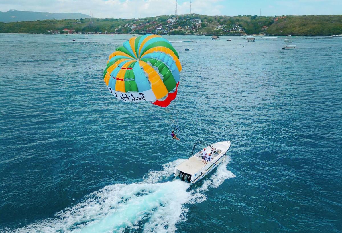 Un gran paracaídas volando sobre un barco en el agua.