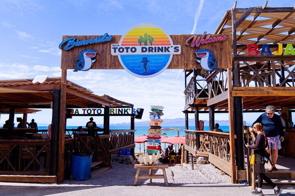 un bar di pesce sulla spiaggia con gente che passeggia