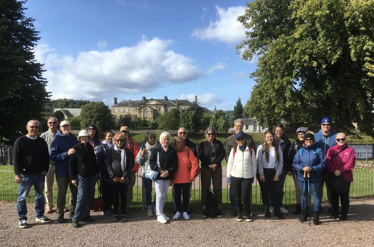 a group of people standing in front of a fence