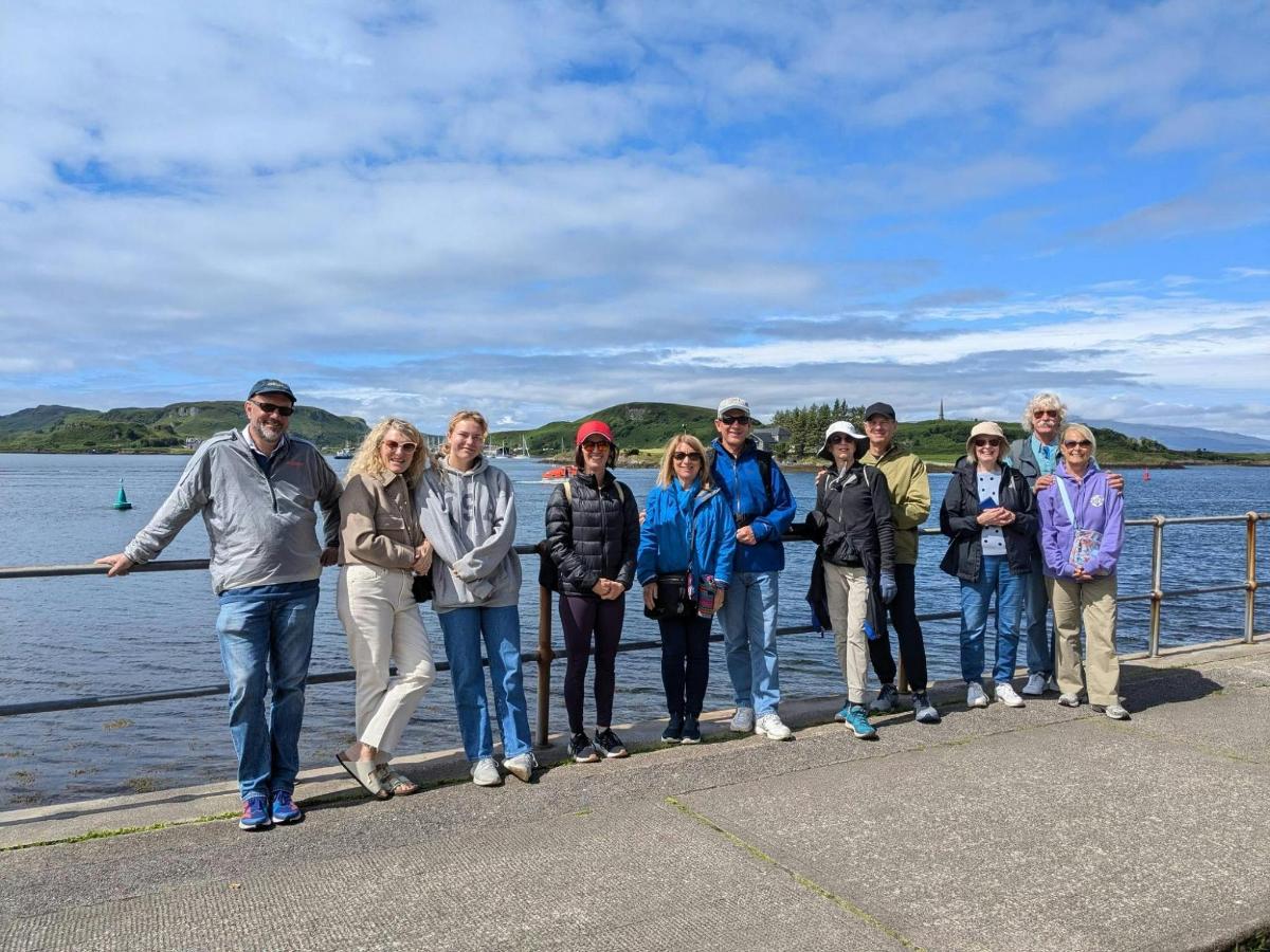 a group of people standing on a pier near the water