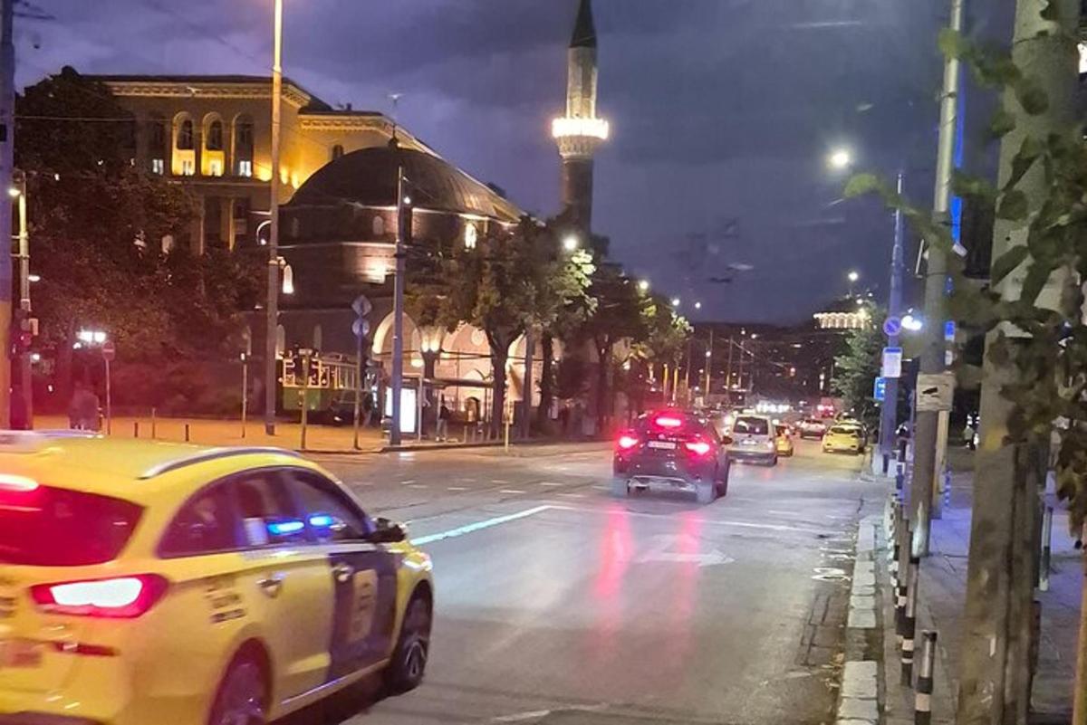 městská ulice v noci s auty jedoucími po ulici