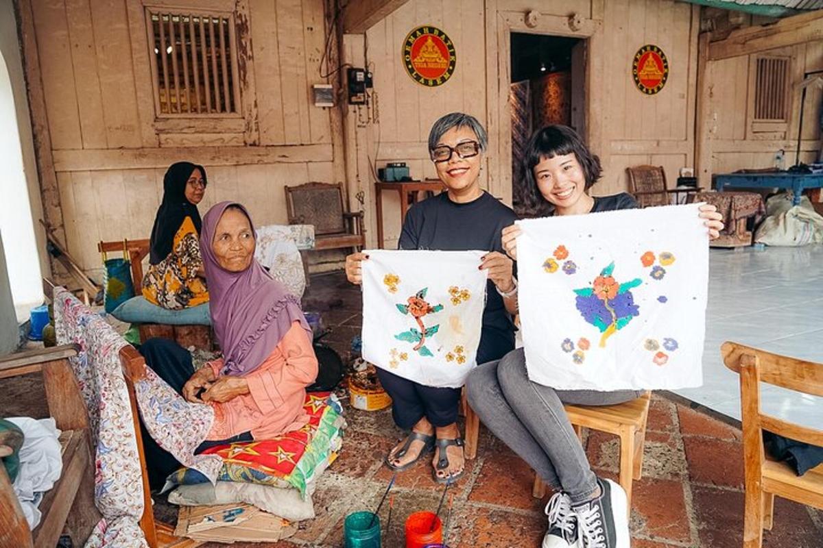 a group of people holding up art canvases