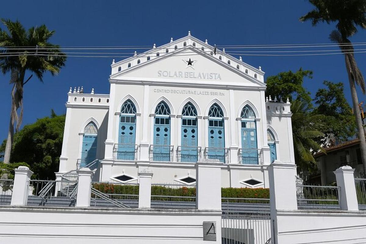 Un gran edificio blanco con un reloj encima.