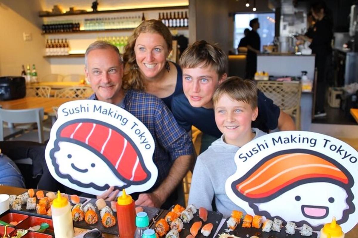 rodina pózuje pro fotku před stoly, kde se dělá sushi