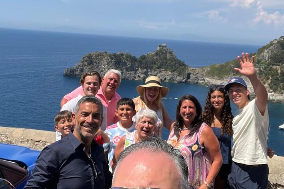 skupina lidí pózujících pro fotografii u oceánu