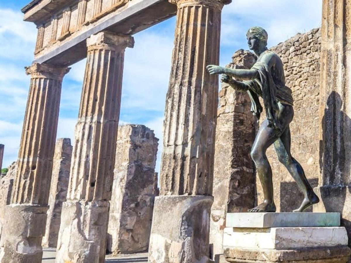 eine Statue eines Mannes, der vor einem Gebäude steht