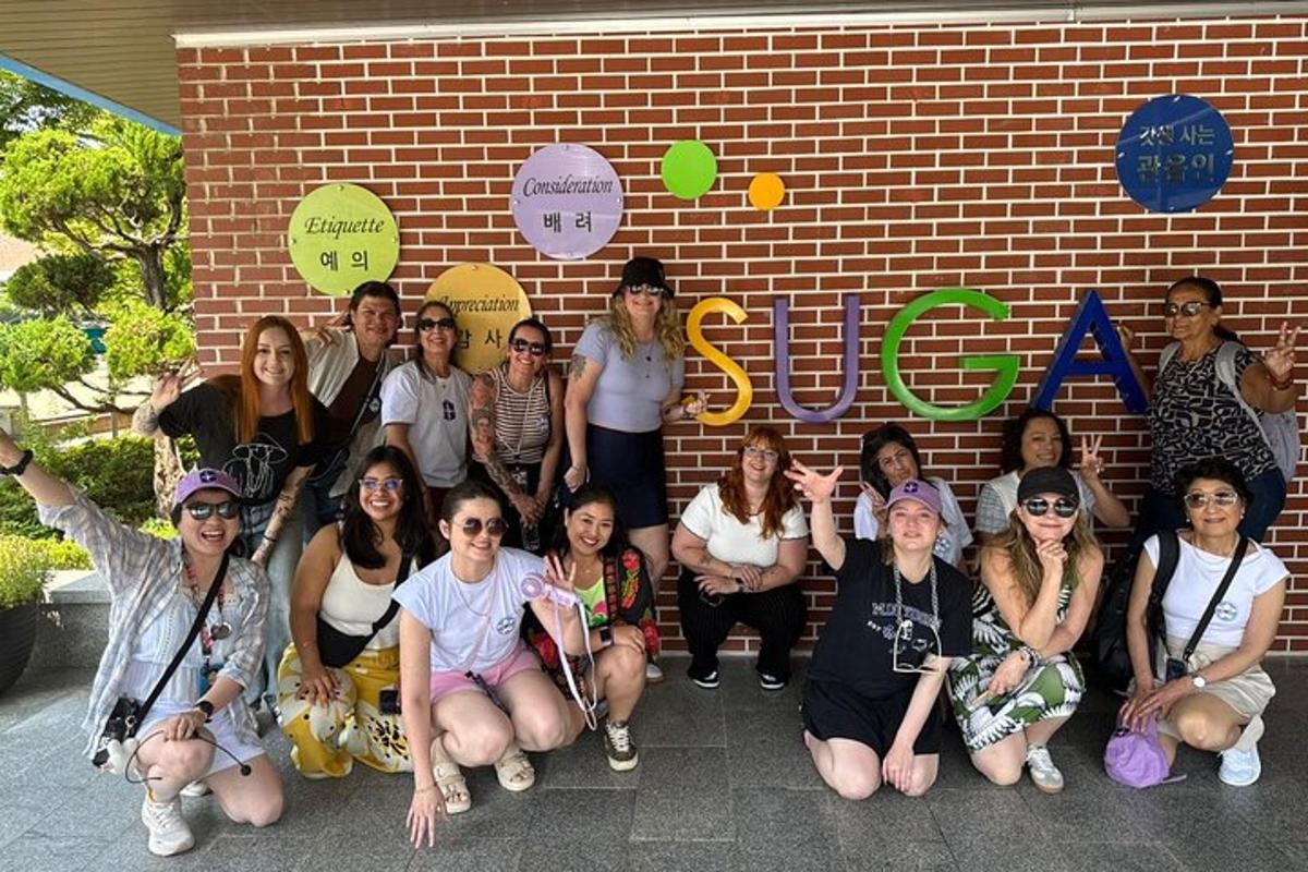 a group of people posing in front of a brick wall