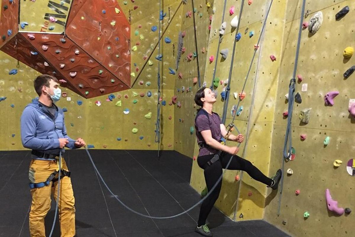 a man and a woman climbing a rock wall