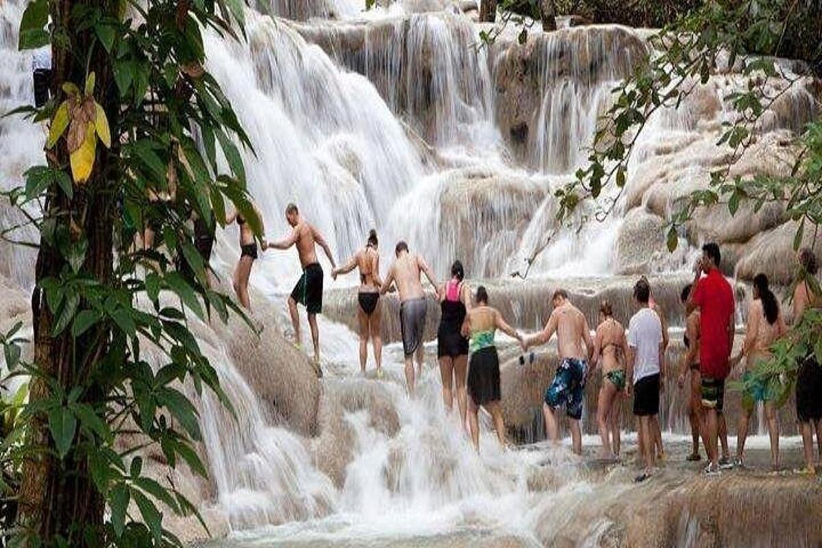 sekumpulan orang berdiri di hadapan air terjun