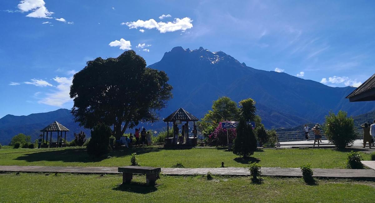 a park with a bench and a mountain in the background