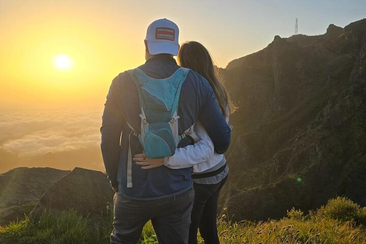 un uomo e una donna in piedi sulla cima di una montagna