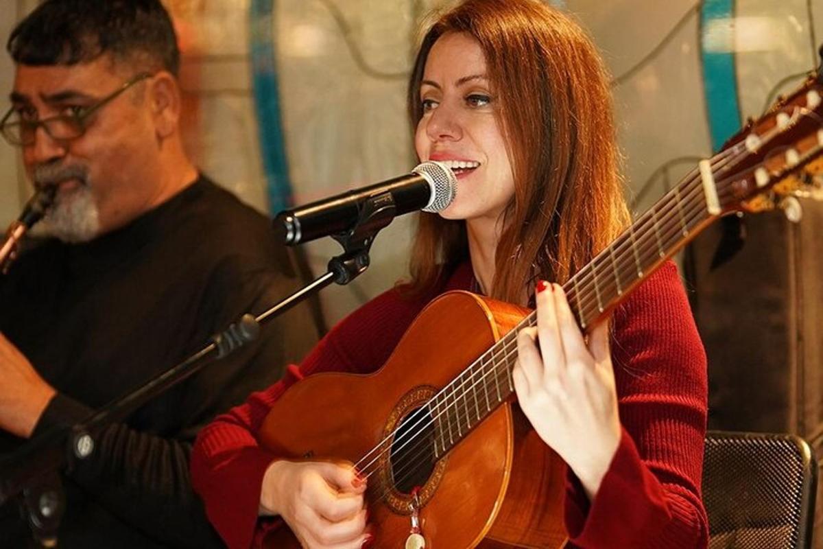 Un hombre y una mujer tocando una guitarra y un micrófono.