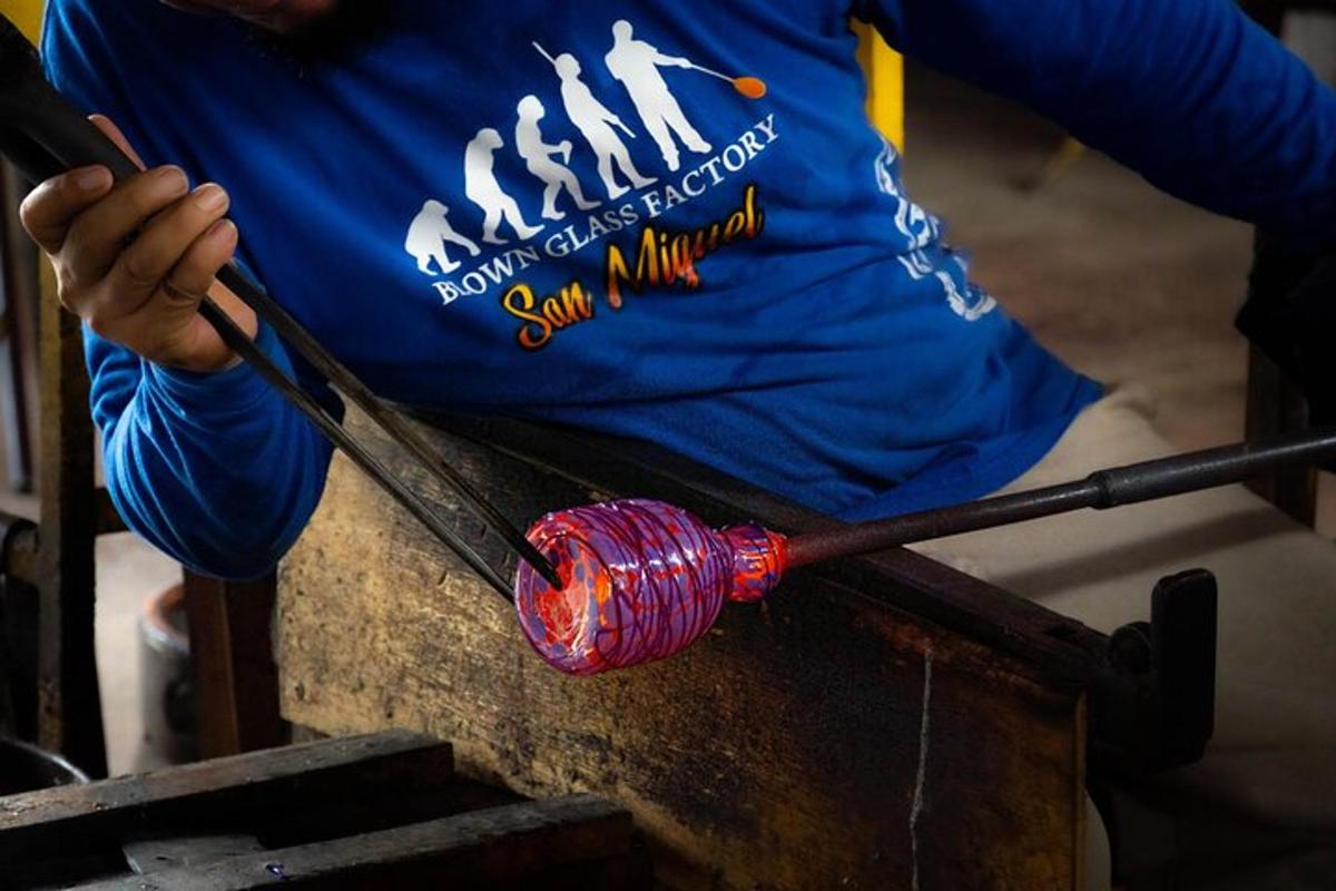 una persona con una camicia blu che tiene in mano un oggetto rosso