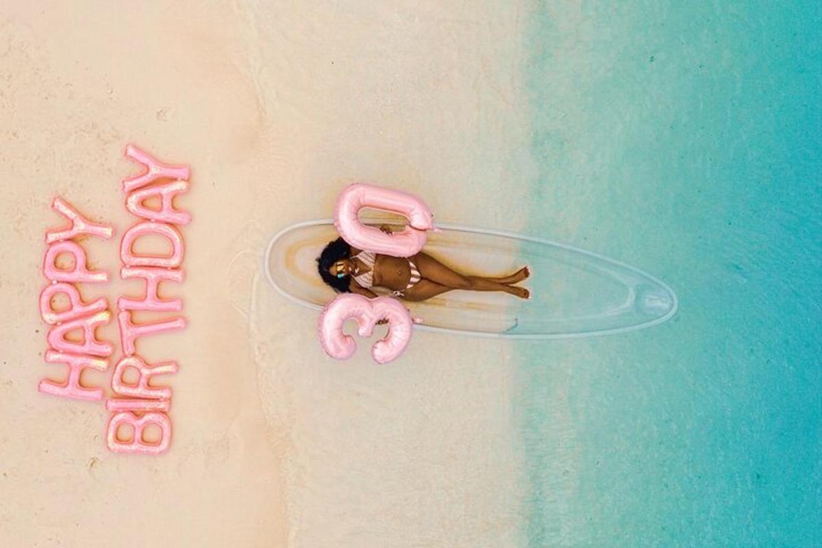 naine lamab liival surfilaual roosade flamingodega