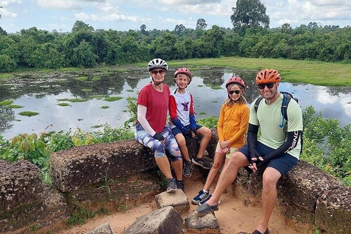 Un grupo de personas sentadas en una roca con sus bicicletas.