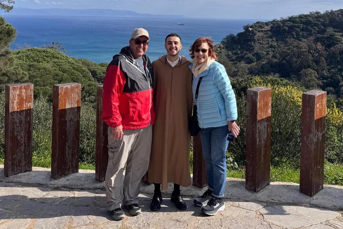 un gruppo di tre persone in piedi sulla cima di una collina