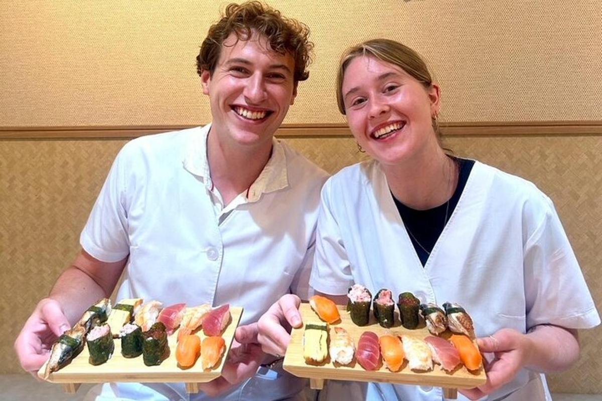 seorang lelaki dan seorang wanita memegang dua pinggan sushi