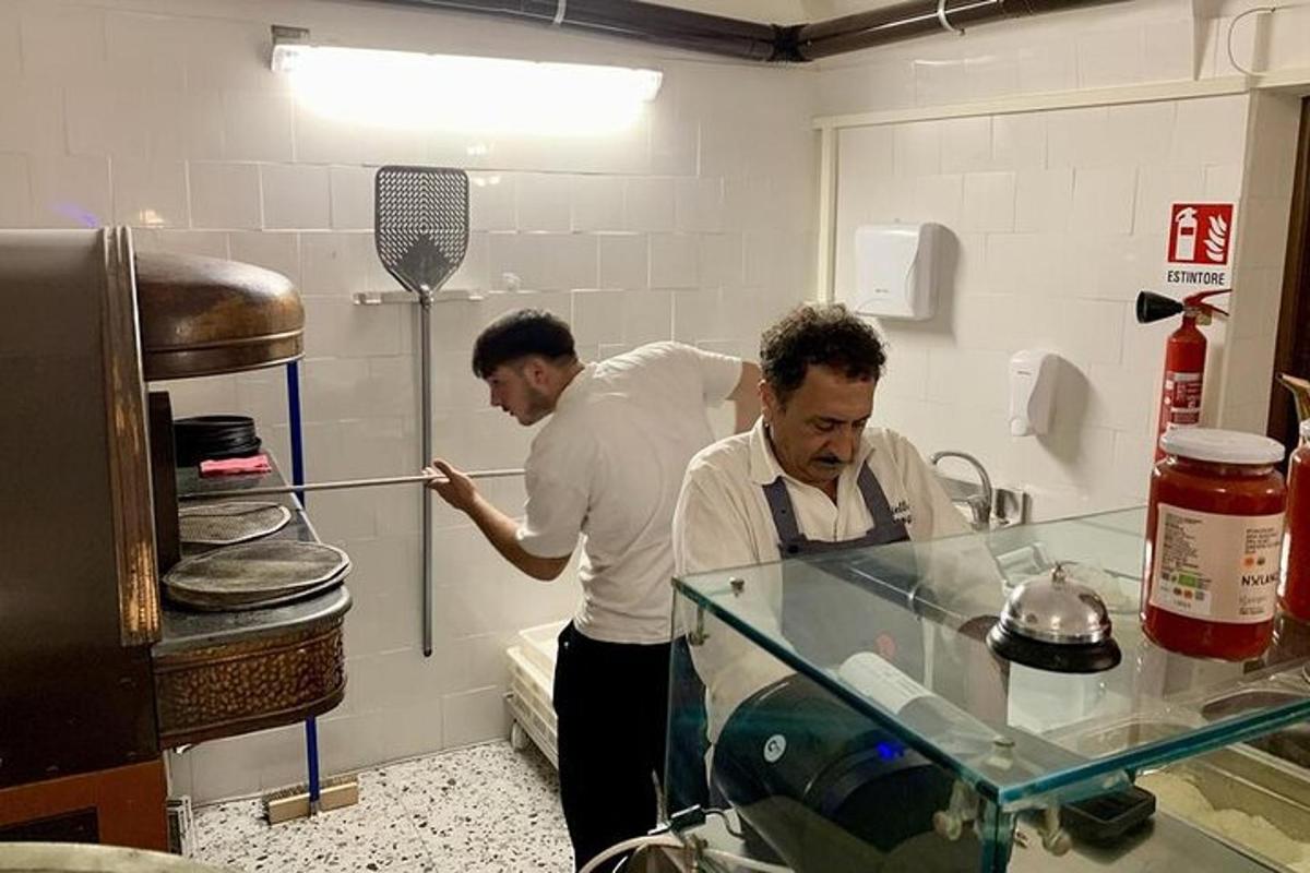 Δύο άντρες στέκονται σε μια κουζίνα και ετοιμάζουν φαγητό