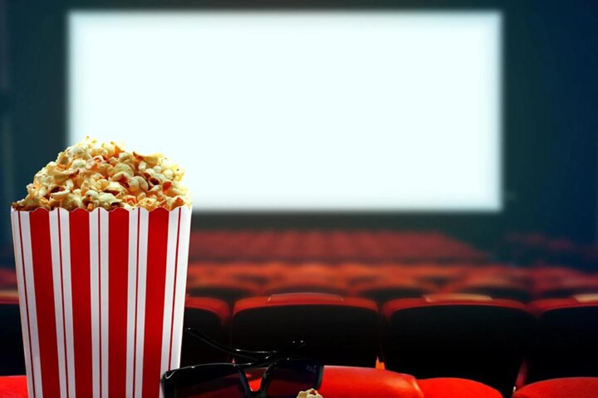 a container of popcorn sitting on a table in an auditorium
