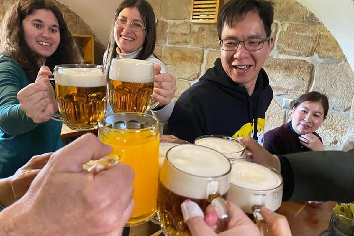 een groep mensen die rond een tafel zitten en bier drinken