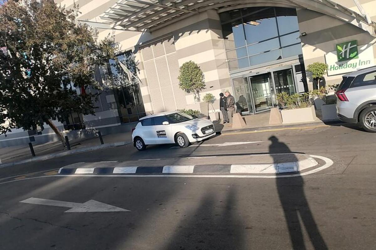 um carro branco estacionado em frente a um prédio