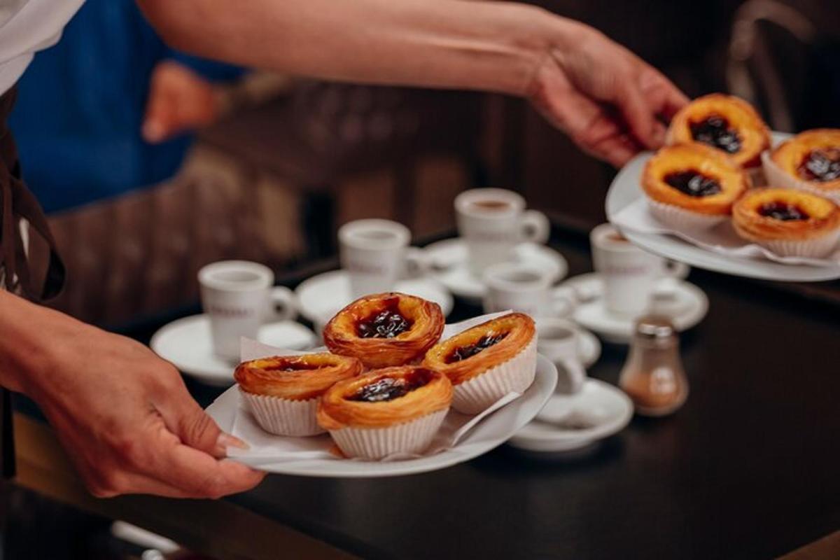 a person holding plates of cupcakes on a table