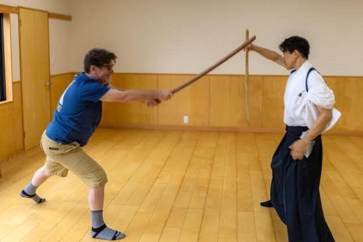 two men are playing with a pole in a dance floor