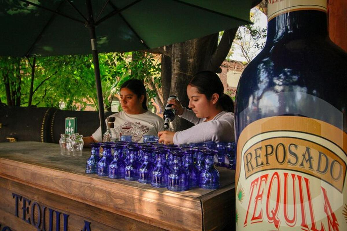 two women sitting at a bar with a bottle of water