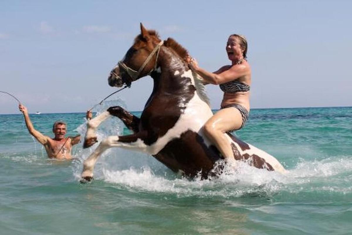 Dvě ženy jedou na koni v oceánu