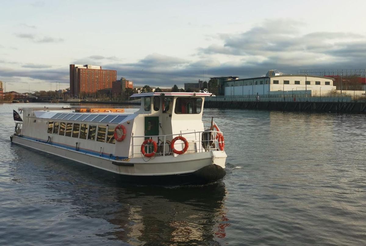 a white boat in the water near a city