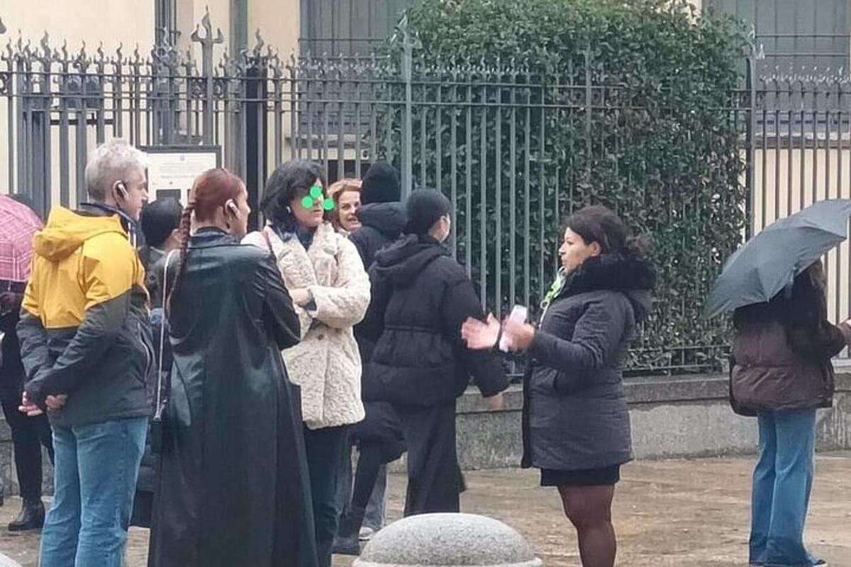 cilvēku grupa, kas stāv pie žoga