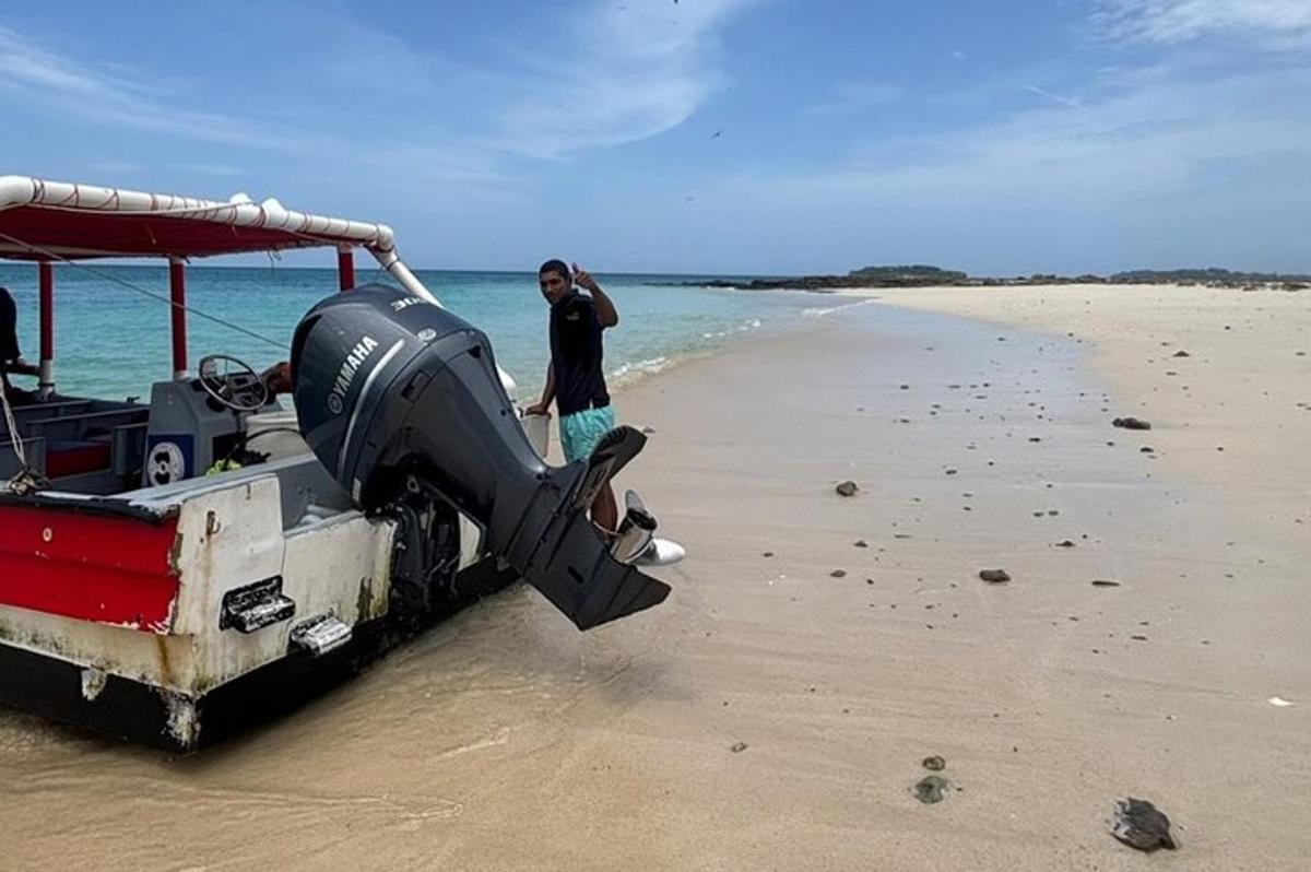 čovjek stoji pored broda na plaži