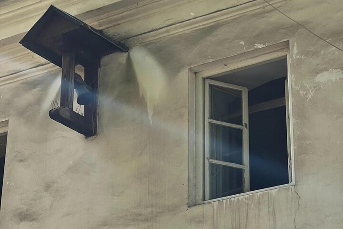 a light on the side of a building with a window