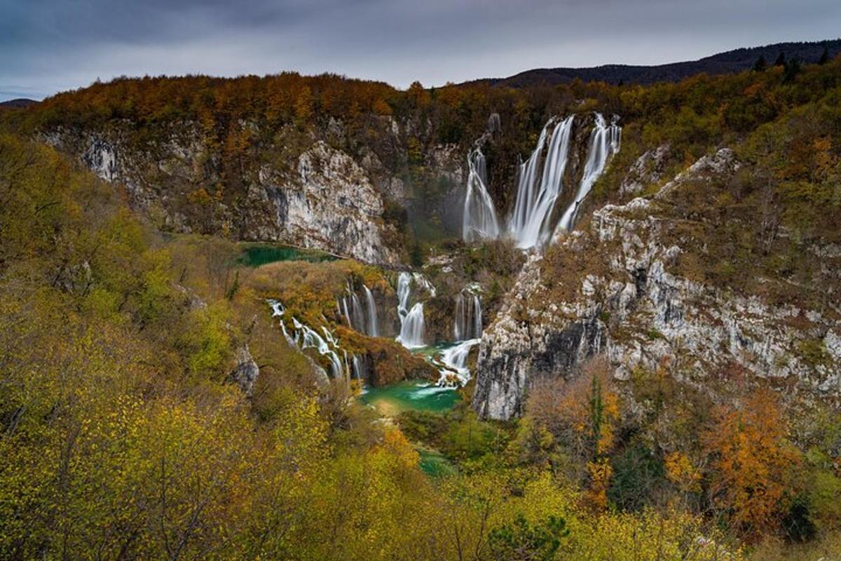 a waterfall in the middle of a mountain with trees