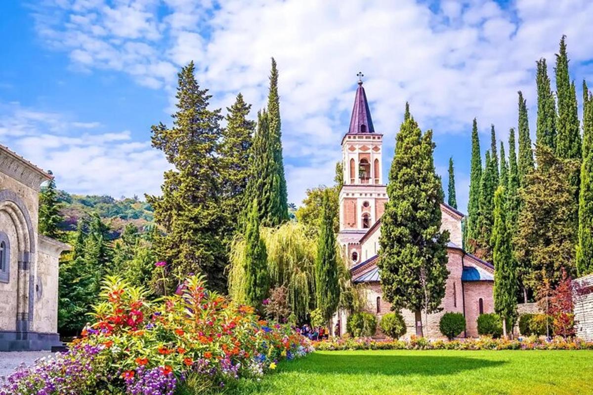 a church with a tower and a garden with flowers