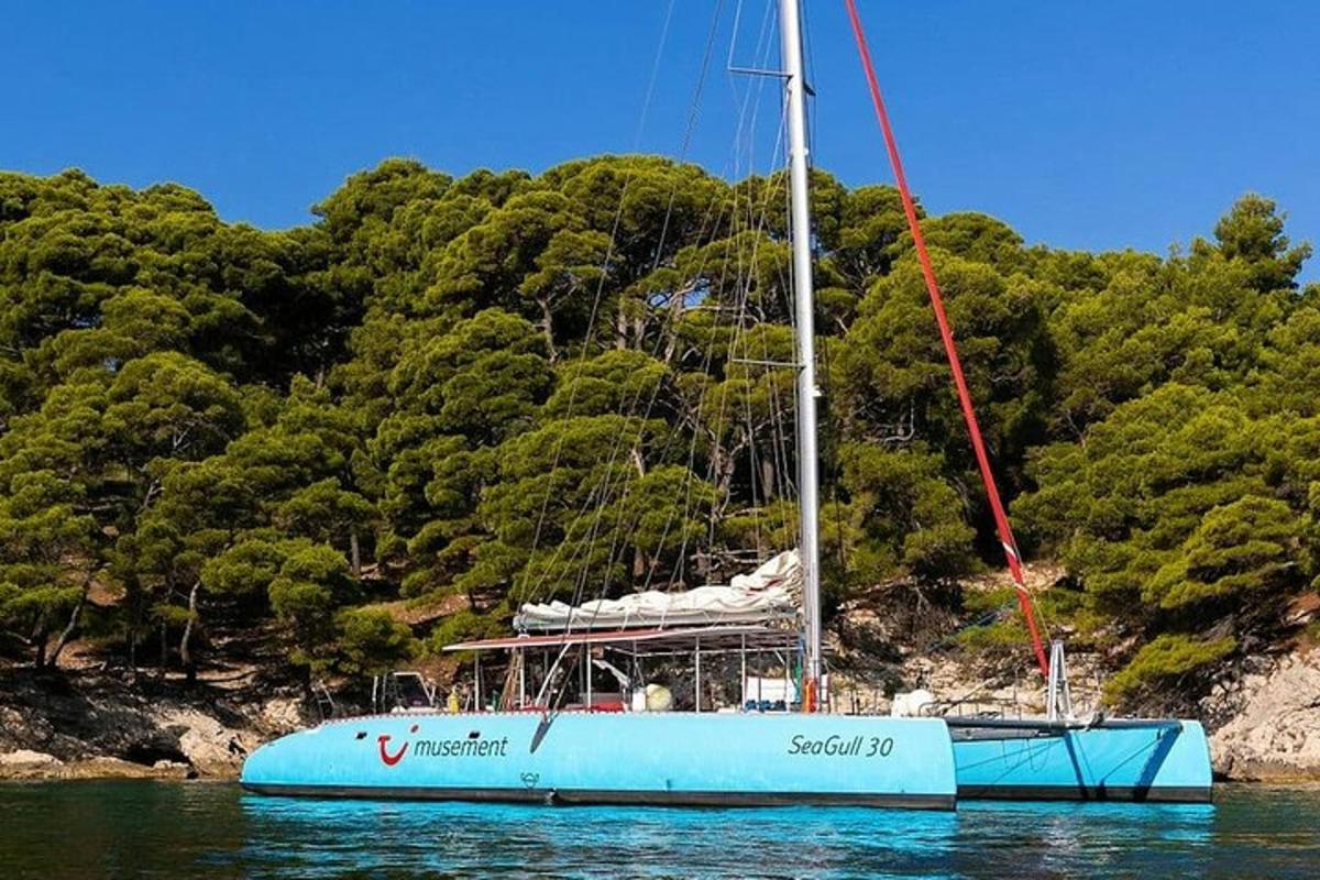 μια μπλε βάρκα που κάθεται στο νερό δίπλα σε ένα βουνό