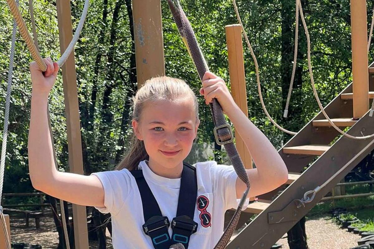 a young girl is on a rope swing