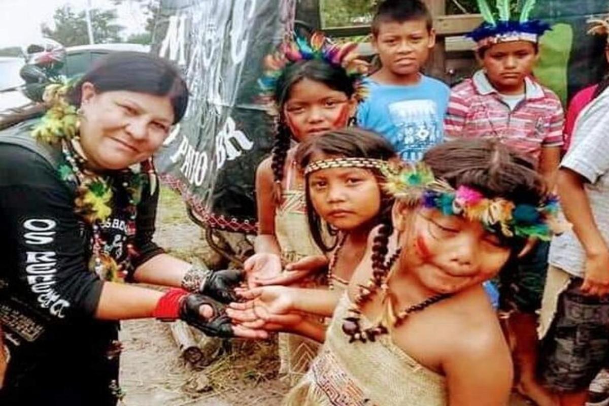 a group of children standing next to a woman