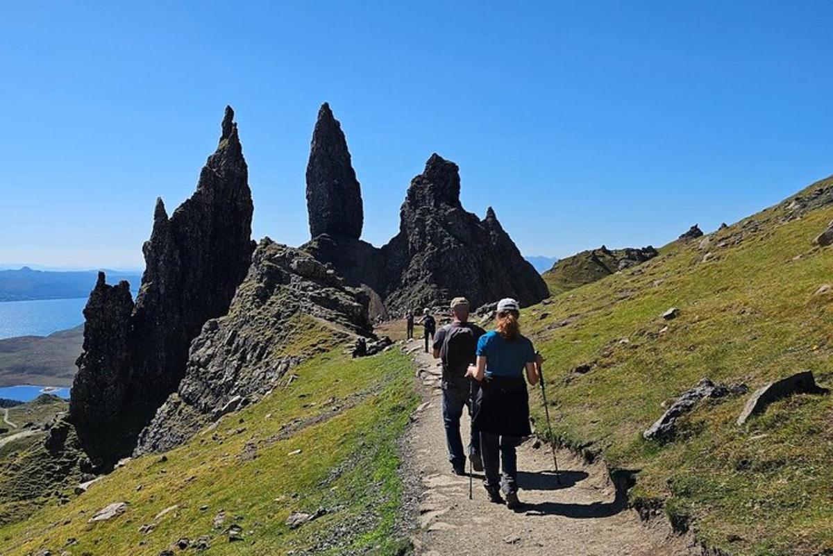 a man and woman walking down a trail on a mountain
