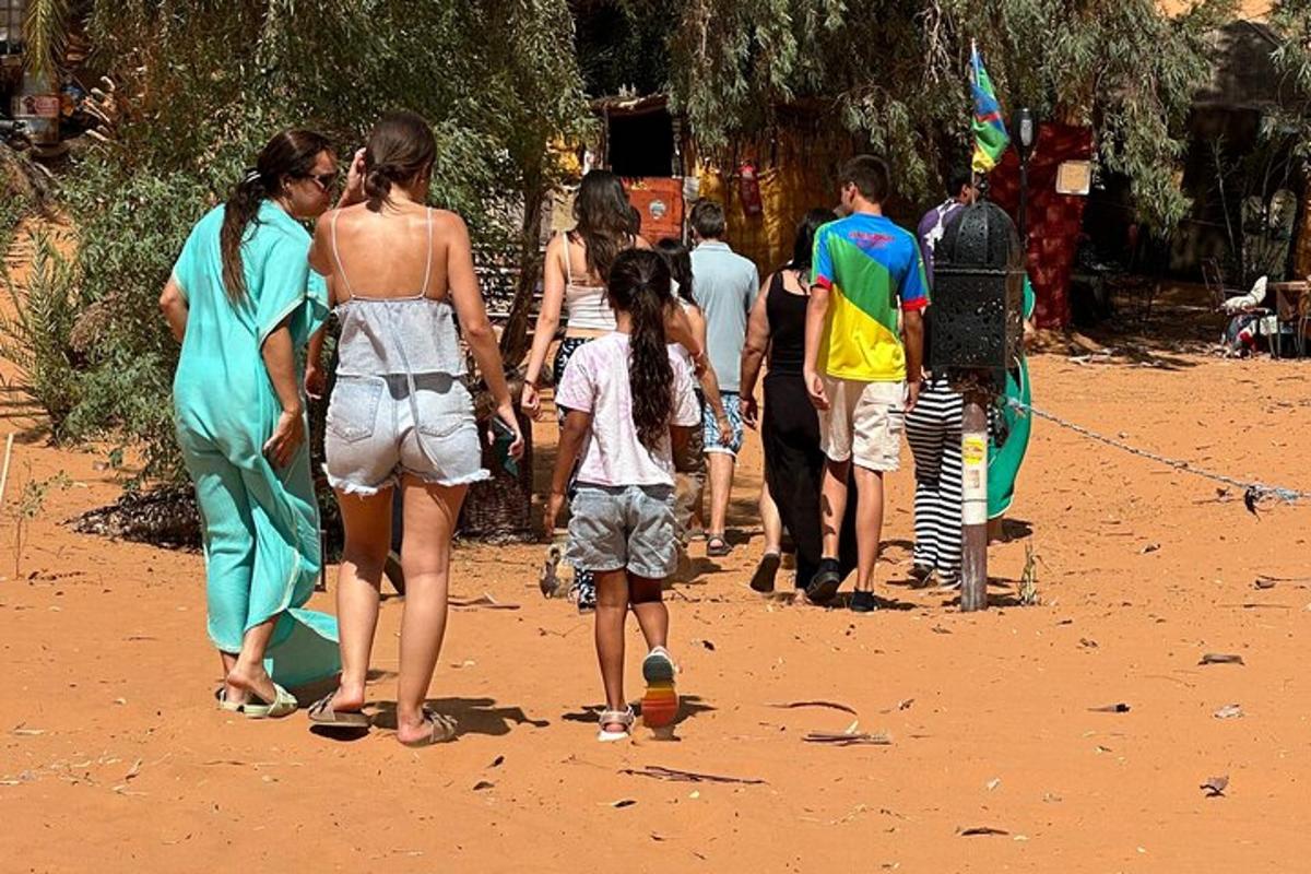 sekumpulan orang berjalan di pantai